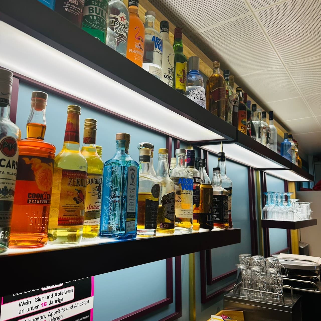 Beleuchtete Bar-Regale mit vielfältiger Spirituosen-Auswahl