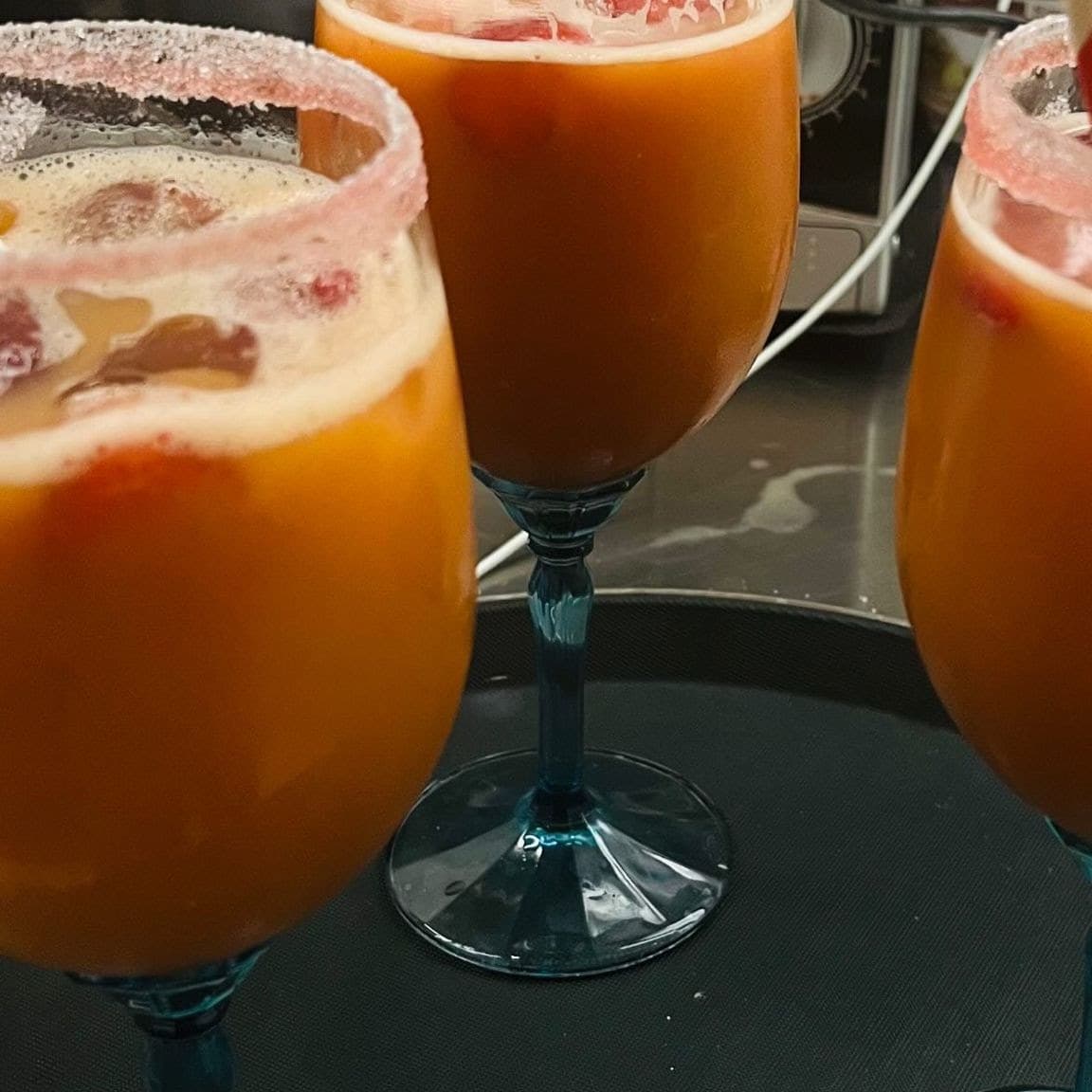 Fruchtpunsch in blauen Gläsern mit Zuckerrand